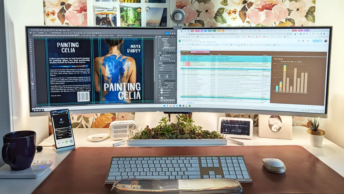 a modern desk with an ultrawide monitor showing a book cover and list with graph